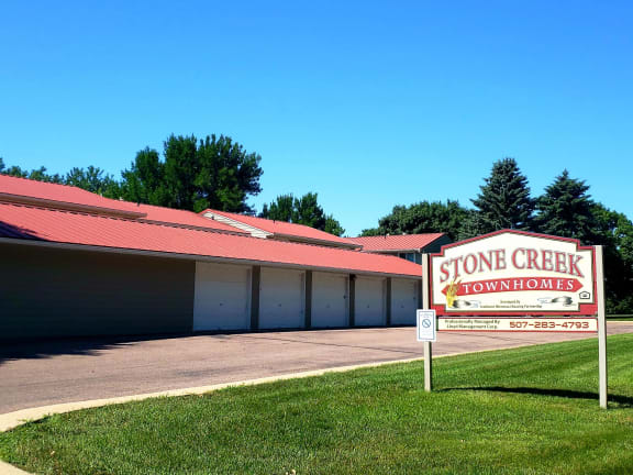 a stone creek townhomes sign in front of a building