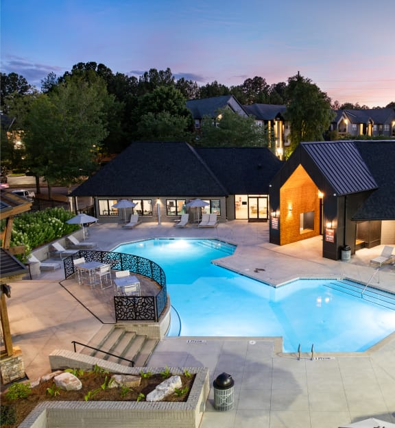 an aerial view of a resort pool and spa at night
