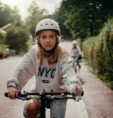 a young girl riding a bike down a street