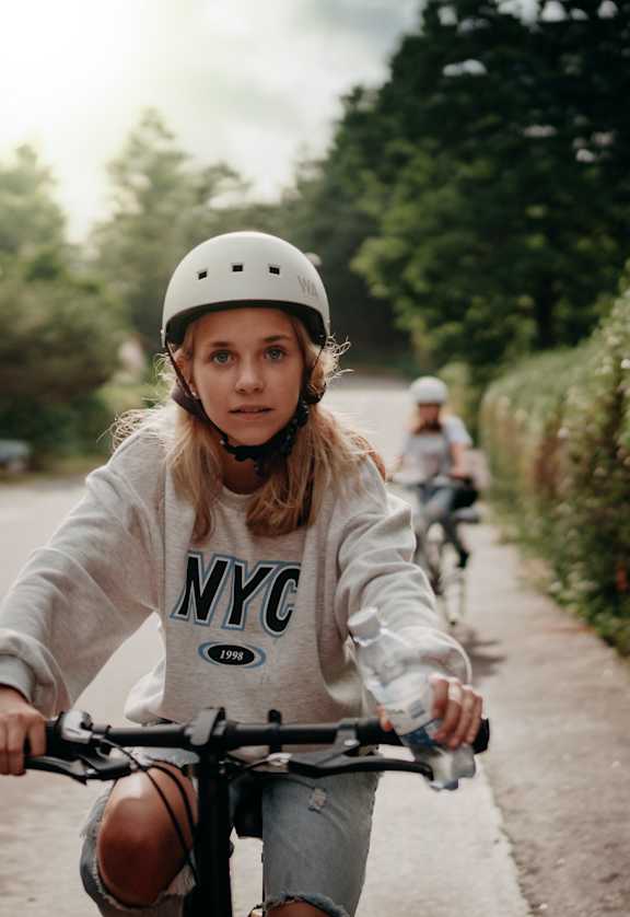 a young girl riding a bike down a street