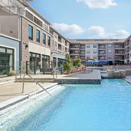 A swimming pool in a residential area surrounded by apartment buildings.