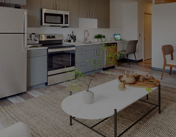 A modern kitchen with a refrigerator, oven, and sink.