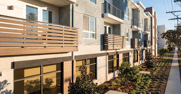 a row of apartment buildings with wooden balconies and a sidewalk