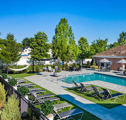 a swimming pool with lounge chairs in front of a building with a resort style pool