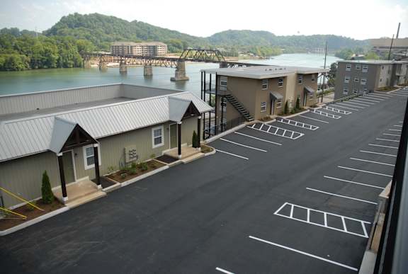 an aerial view of a parking lot with buildings and a river