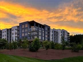 A large apartment complex with a grassy area in front.
