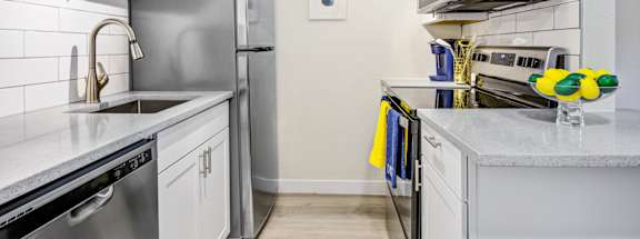 a kitchen with white cabinets and stainless steel appliances