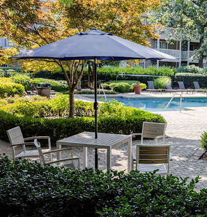a swimming pool with tables and chairs and an umbrella