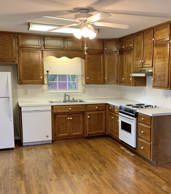 an empty kitchen with wooden floors and wooden cabinets