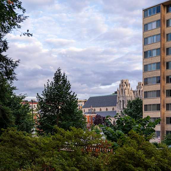 A view of a cityscape with a church and a tall building in the background.