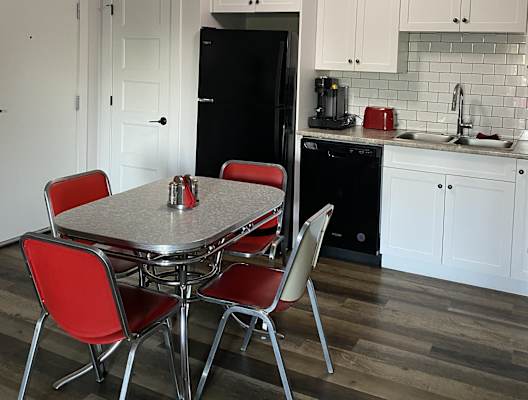 a kitchen with white cabinets and a table and chairs