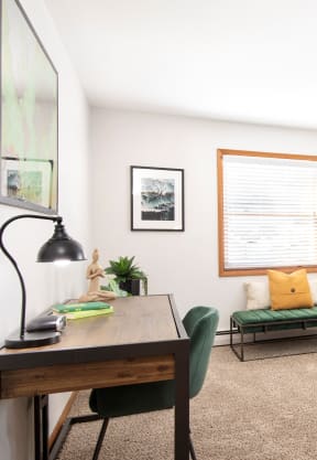 a living room with two windows and a desk with a green chair at Preserve West, Wisconsin