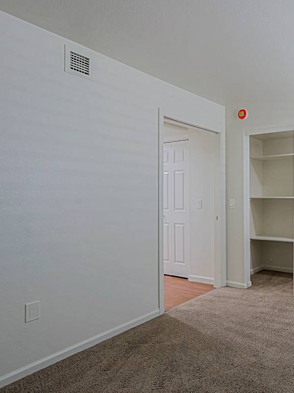 A room with a carpeted floor and a white door.