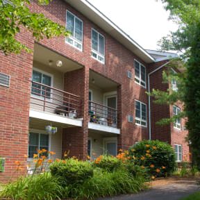 a red brick apartment building with balconies and flowers