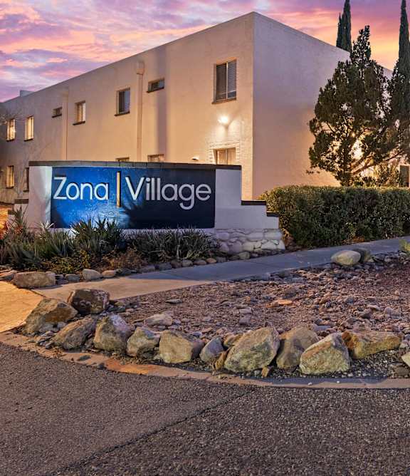 A building with a sign that says Zona Village.