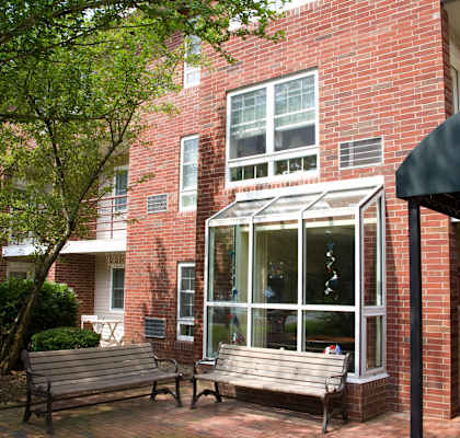 two benches in front of a brick building with a window