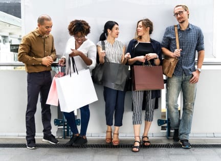 a group of people standing in an airport with their shopping bags