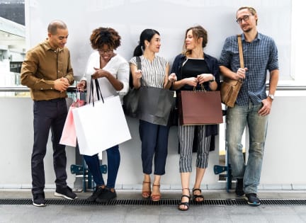 a group of people standing in an airport with their shopping bags