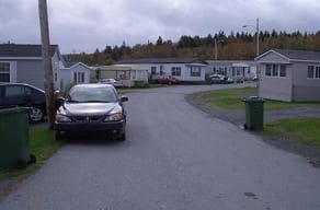 A car is parked on a driveway in front of a house.