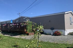 A house with a grey siding and a white baseboard.