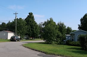 A residential street with a car parked on the side.