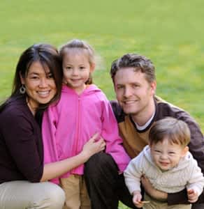 a group of people sitting on top of a grass covered field