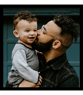 a man holding a little boy in his arms