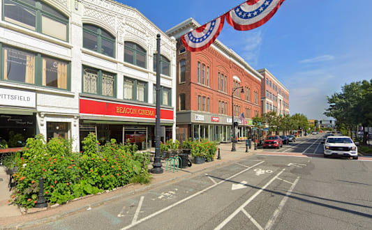 A street view with a cafe and a red building.