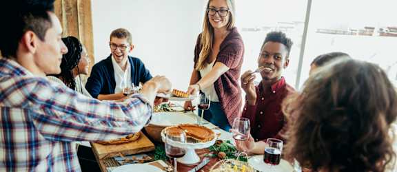 A group of people are gathered around a table enjoying a meal together.