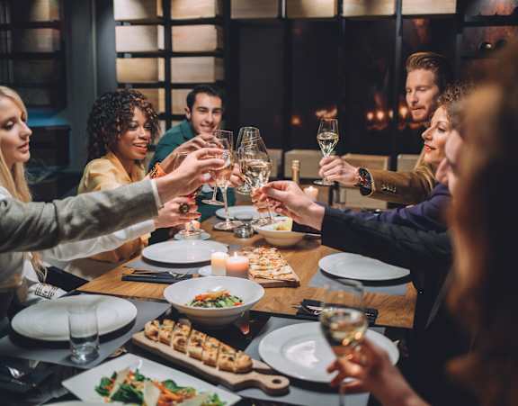 A group of people toasting with wine glasses at a dinner table.at Palazzo Townhomes, Phoenix, AZ 85008