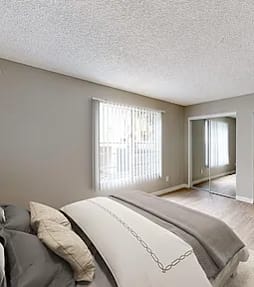 A bedroom with a large bed and a dresser.