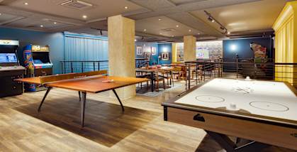 A room with a pool table and a shuffleboard table.