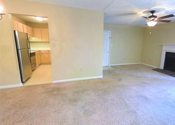 a living room filled with furniture and a ceiling fan