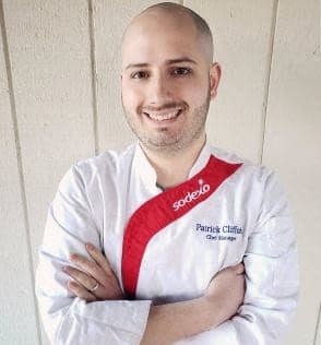 a man wearing a white shirt and a red tie with his arms crossed