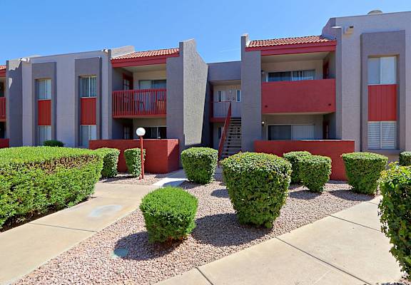 a building with a courtyard and hedges in front of it at Spring Meadow Apartments, Glendale, AZ, 85302