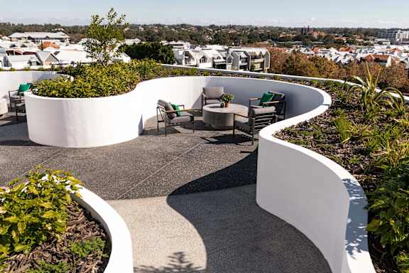 a terrace with a table and chairs with a view of the city in the background