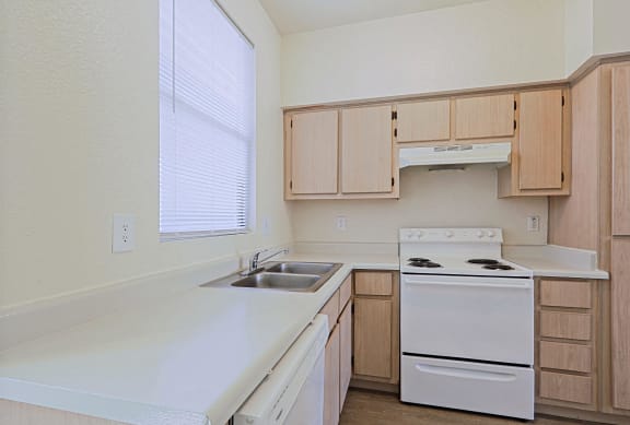 an empty kitchen with white appliances and wooden cabinets