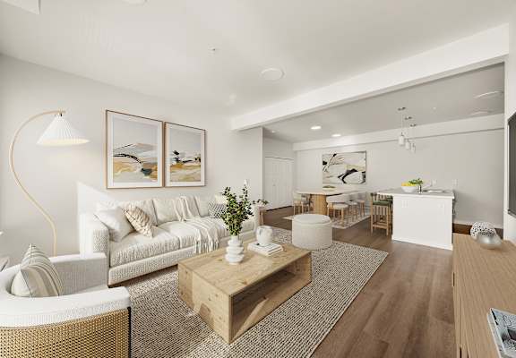 A modern living room with a white sofa, a wooden coffee table, and a large painting on the wall.