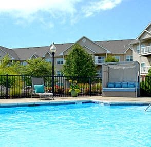 a swimming pool with a building in the background at Villas At Crystal Lake, Swansea, IL, 62226