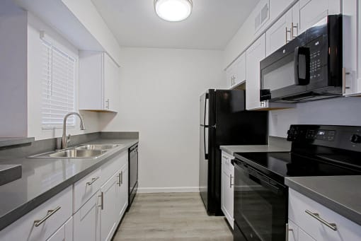 the preserve at ballantyne commons apartment kitchen with black appliances and white cabinets