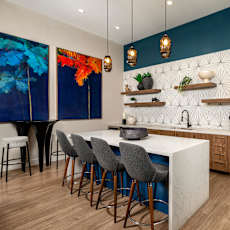 A kitchen with a white counter and blue chairs.