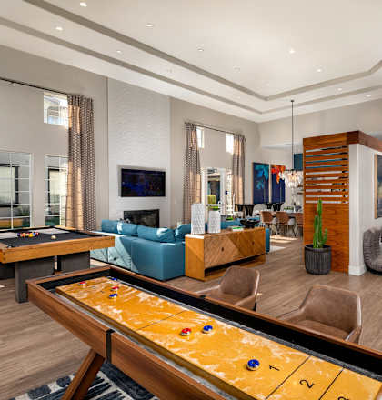 A shiny billiard table is in the middle of a well-furnished room.