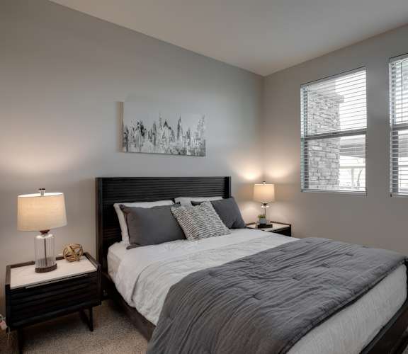 A bedroom with a large bed and a painting on the wall.