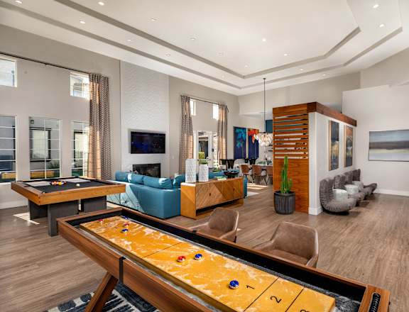 A shiny billiard table is in the middle of a well-furnished room.