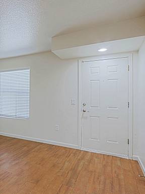 A room with a white door and a window with blinds.