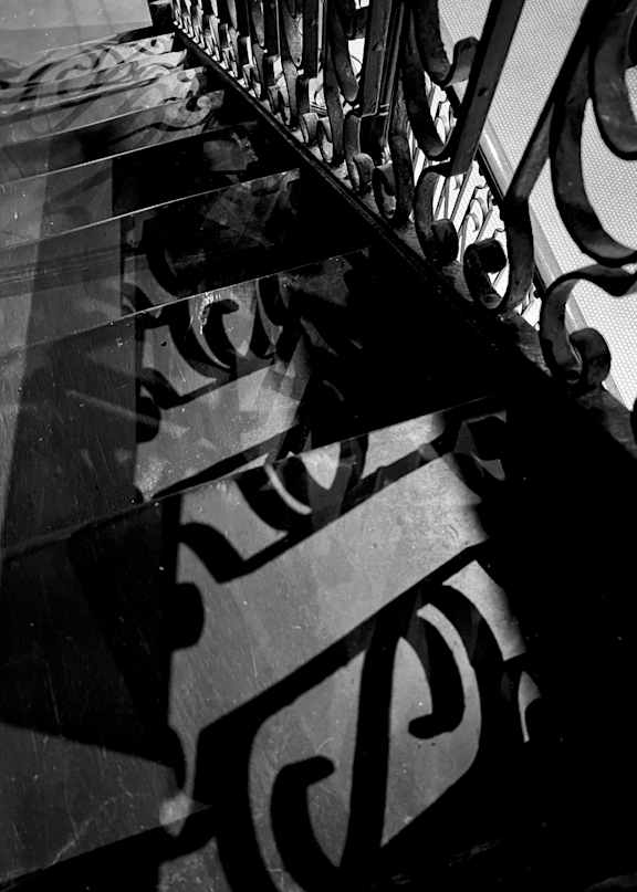 A black and white image of a staircase with ornate railings.