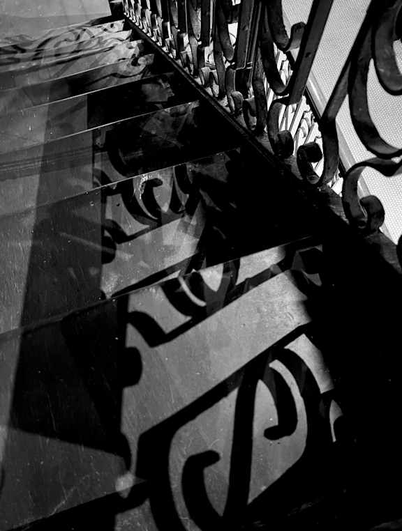 A black and white image of a staircase with ornate railings.