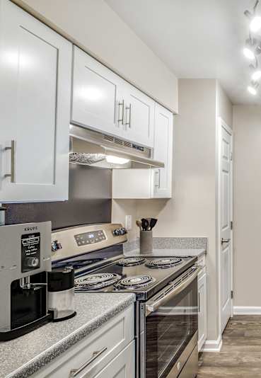 A kitchen with a stove, refrigerator, and sink.