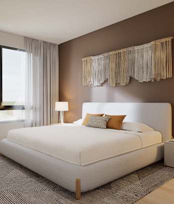 A bedroom with a large bed, a chair, and a window with curtains.
