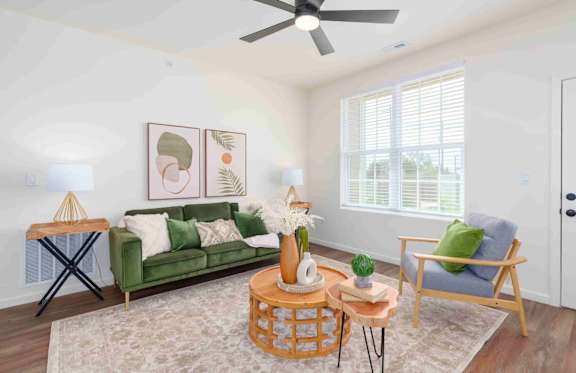 Picture of a living room with a green couch, wood coffee table, and an accent chair.